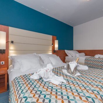 Hotel room with two beds and decorative folded towels