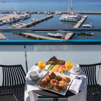 Breakfast set on a balcony with a view of the harbor
