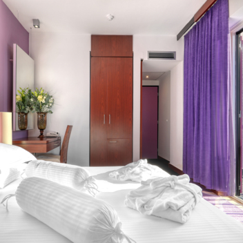 modern hotel room with double bed and balcony overlooking the sea