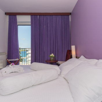 bright hotel room with double bed and balcony