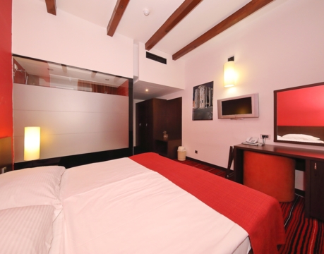 moderna hotelska soba s bračnim krevetom i radnim stolom